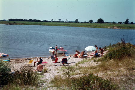 852028 Afbeelding van recreanten op een strandje aan de Lek bij Tull en 't Waal (gemeente Houten).